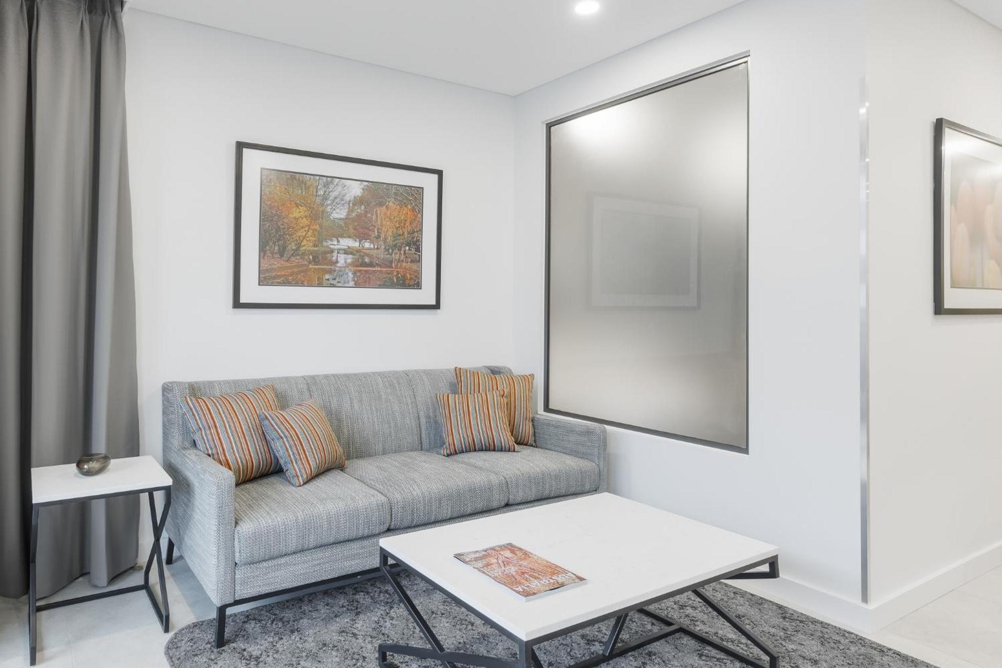 Meriton Suites Canberra Esterno foto A living room with a sofa