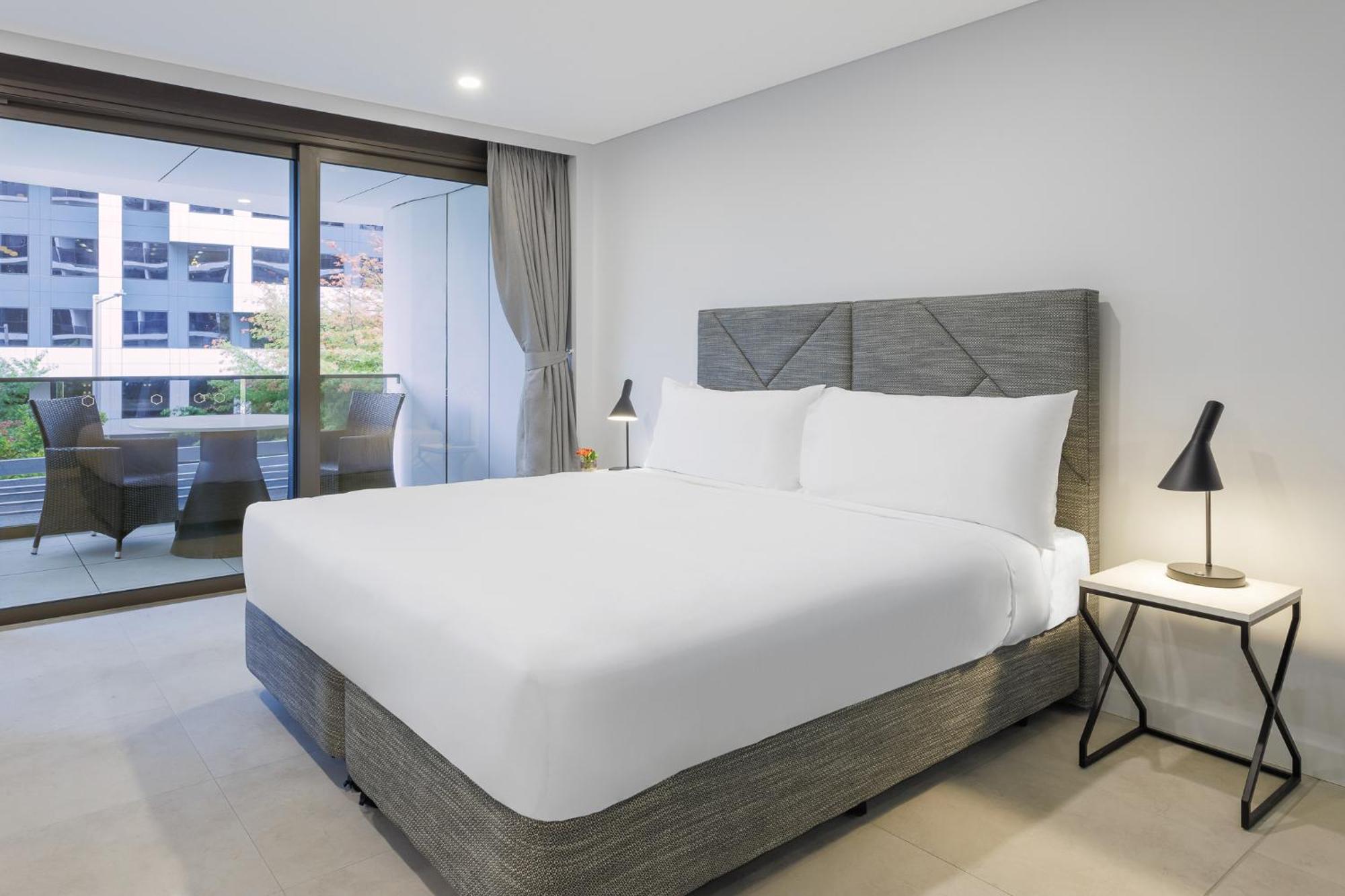 Meriton Suites Canberra Esterno foto A bed with a mattress